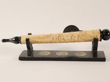 carved wooden pen on stand with black base on white background