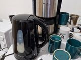 une table couverte de tasses à café et de bouilloires