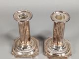 pair of silver candlesticks on a white background