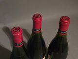 three bottles of wine sitting on top of a table next to each other