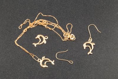 un gros plan d'un collier et de boucles d'oreilles posés sur une surface noire