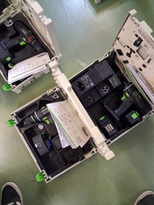 deux boîtes ouvertes contenant des télécommandes, posées par terre