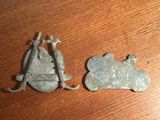 une paire de boutons anciens en métal argenté posés sur une table en bois