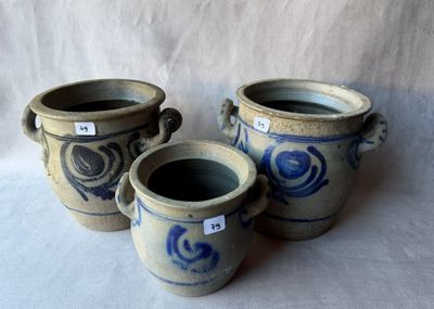 trois vases bleus et blancs posés sur une surface blanche
