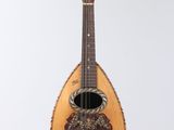 a guitar hanging from a string on a white wall