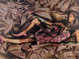 une photo d'une femme allongée sur un lit, les jambes relevées