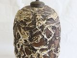 brown and white vase with a black handle on a white background