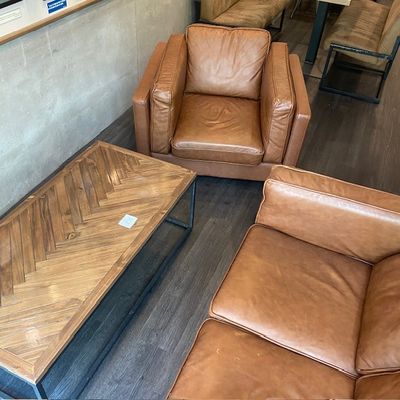 deux canapés en cuir marron et une table basse dans un salon