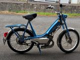 a blue motor bike parked on the side of the road
