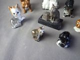 a lot of small figurines of cats on a table
