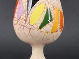a white vase with a multicolored design on it