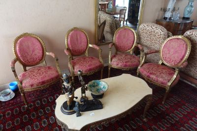 plusieurs chaises et une table basse dans une pièce où se trouve un miroir