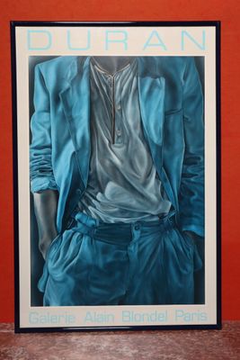 une image représentant une photo encadrée d'un homme en costume bleu