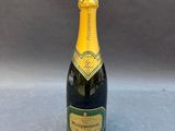a bottle of champagne on a table with a gray background
