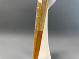 un vase blanc muni d'une poignée en bois, posé sur une table