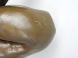 a close up of a bronze statue of a person holding a banana
