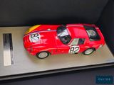 a red toy car in a display case on a table