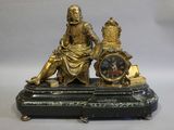une statue représentant un homme et une femme assis sur une horloge