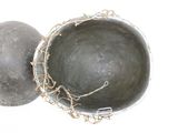 a metal bowl and a metal ball on a white surface