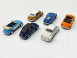 several toy cars are lined up in a row on a white surface