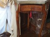 une petite table sur laquelle est posé un livre, à côté d'un rideau