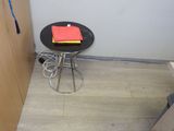 une petite table sur laquelle est posé un livre, dans un coin de la pièce