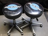 two black stools sitting on top of a table next to a red car