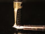a small metal object on a table next to a small metal object