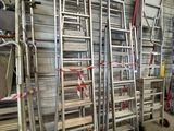 several ladders are lined up against a wall in a warehouse