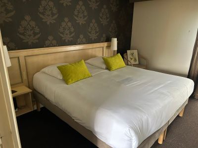 un lit avec des draps blancs et des oreillers jaunes dans une chambre