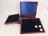 three wooden boxes with coins in them on a white surface