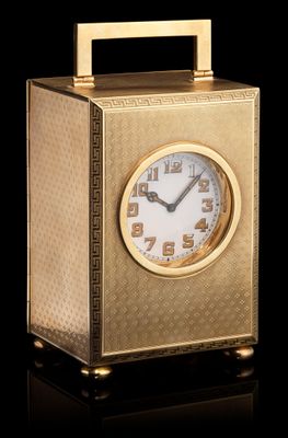 une horloge dorée posée sur une surface noire