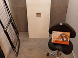 une chaise noire dans un coin d'une pièce, sur laquelle est posé un ordinateur portable