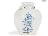 un vase blanc orné d'un motif floral bleu
