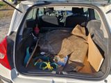 l'arrière d'une voiture blanche dont le coffre est rempli d'objets