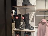 several pairs of rain boots on a shelf in a store