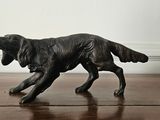 a figurine of a dog running on a wooden floor