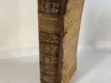 an old book sitting on top of a table next to a white wall