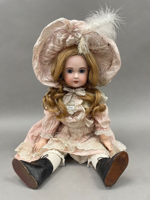 un gros plan d'une poupée portant une robe rose et un chapeau