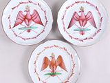 trois assiettes ornées d'oiseaux, posées sur une table