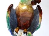a figurine of a parrot perched on a branch
