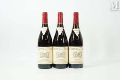 three bottles of red wine sitting on top of a white table