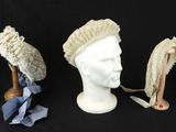 trois chapeaux sont alignés sur une tête de mannequin