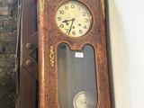 a grandfather clock hanging on the wall next to a stair case