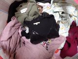 a pile of clothes in a basket on the floor