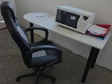 un bureau d'ordinateur sur lequel est posé un micro-ondes