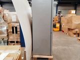a large refrigerator in the middle of a warehouse with boxes on the floor