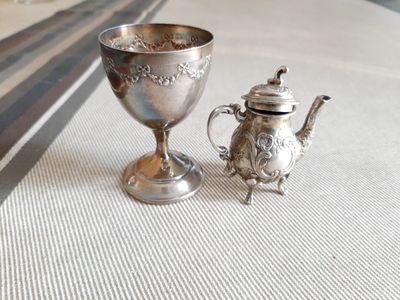 une théière en argent et une théière en argent posées sur une table
