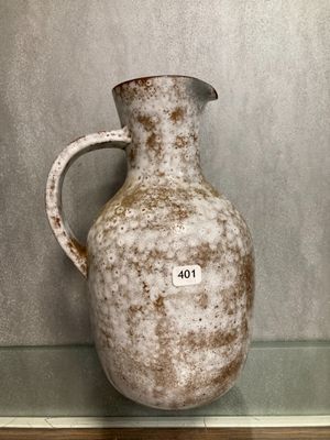 un vase blanc posé sur une étagère en verre dans une pièce