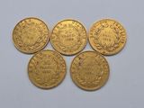 four gold sovereigns, one of which has a crown on top of it